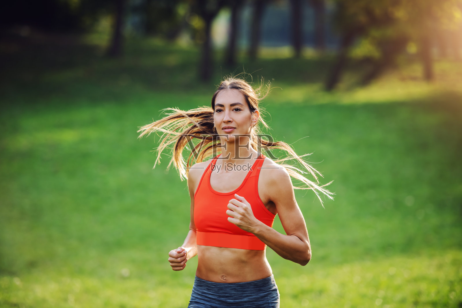 年轻有吸引力的fit女运动员与健康的习惯跑在自然的相机。早上的时间。照片摄影图片