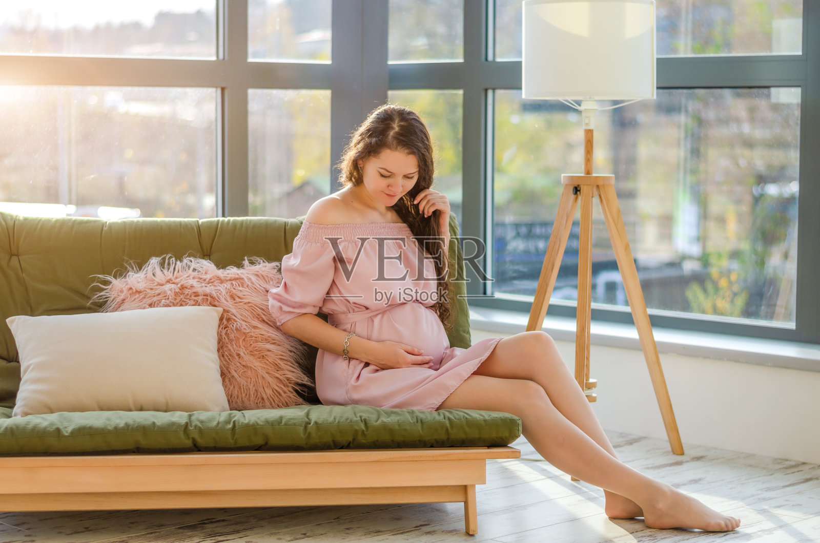 年轻怀孕的年轻女子享受阳光早晨附近的大窗户在家里照片摄影图片