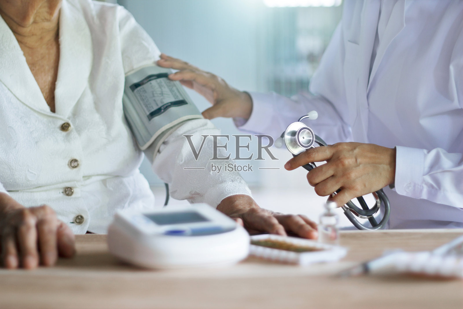 医生用听诊器照顾和检查老年妇女患者的血压，在医院背景下，老年医疗保健。照片摄影图片