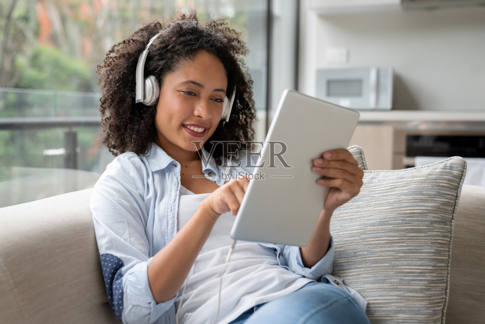 女人在家里用平板电脑听音乐照片摄影图片