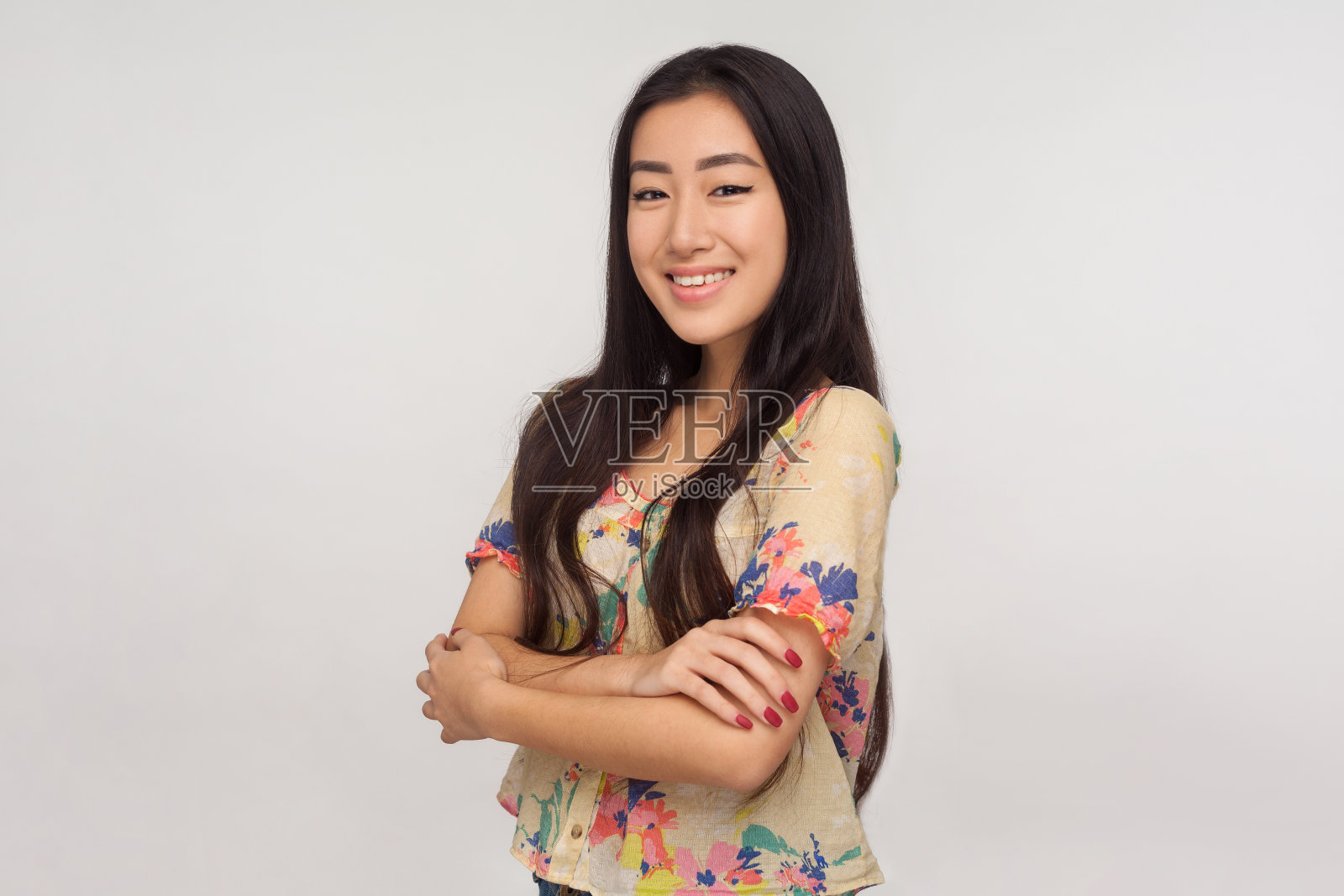 冷静友好善良的亚洲女孩的肖像在夏季衬衫站与交叉的手和看着相机与牙齿的微笑照片摄影图片