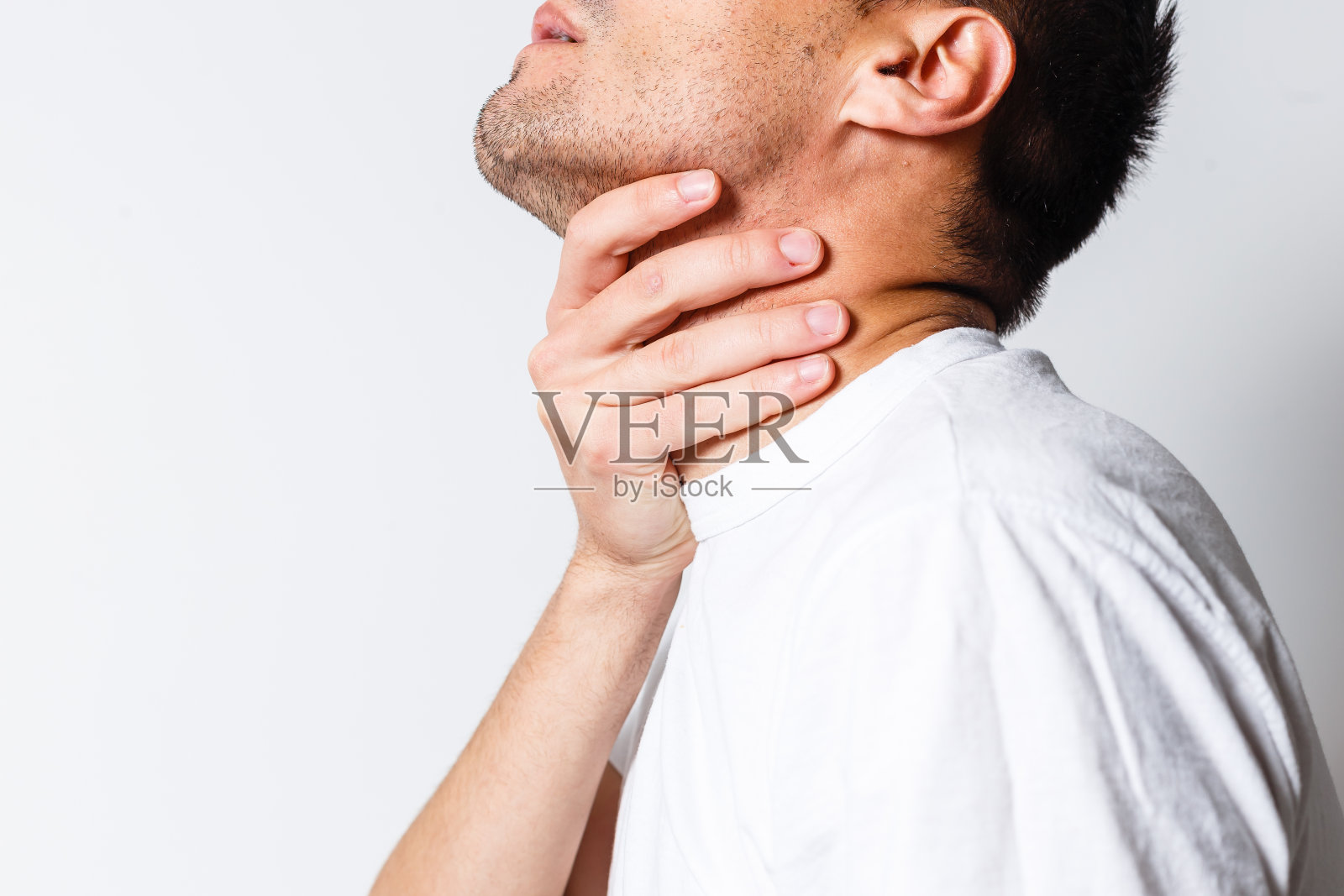 喉咙痛的男人。触摸颈部。红点照片摄影图片