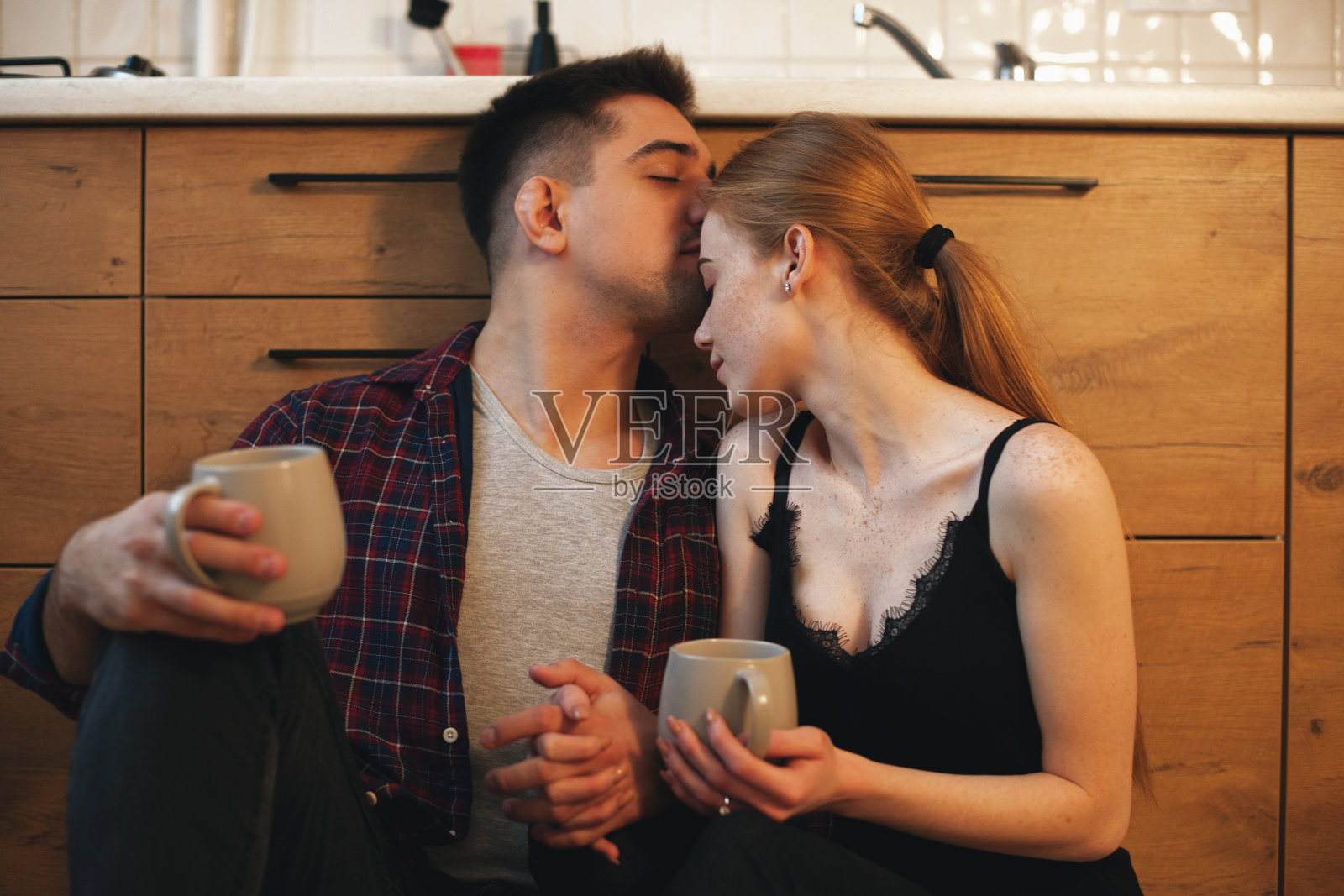 迷人的白种夫妇早上在地板上喝咖啡享受他们在一起的时刻照片摄影图片