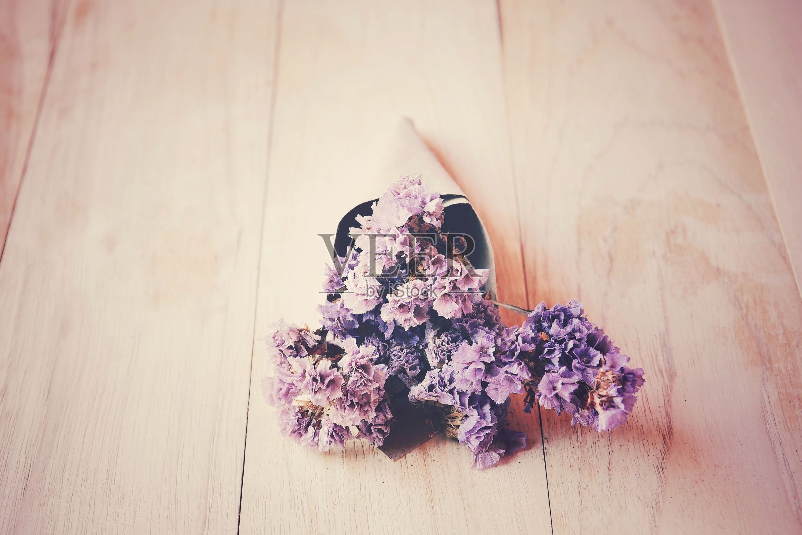 特写干紫色的花在木桌上。照片摄影图片