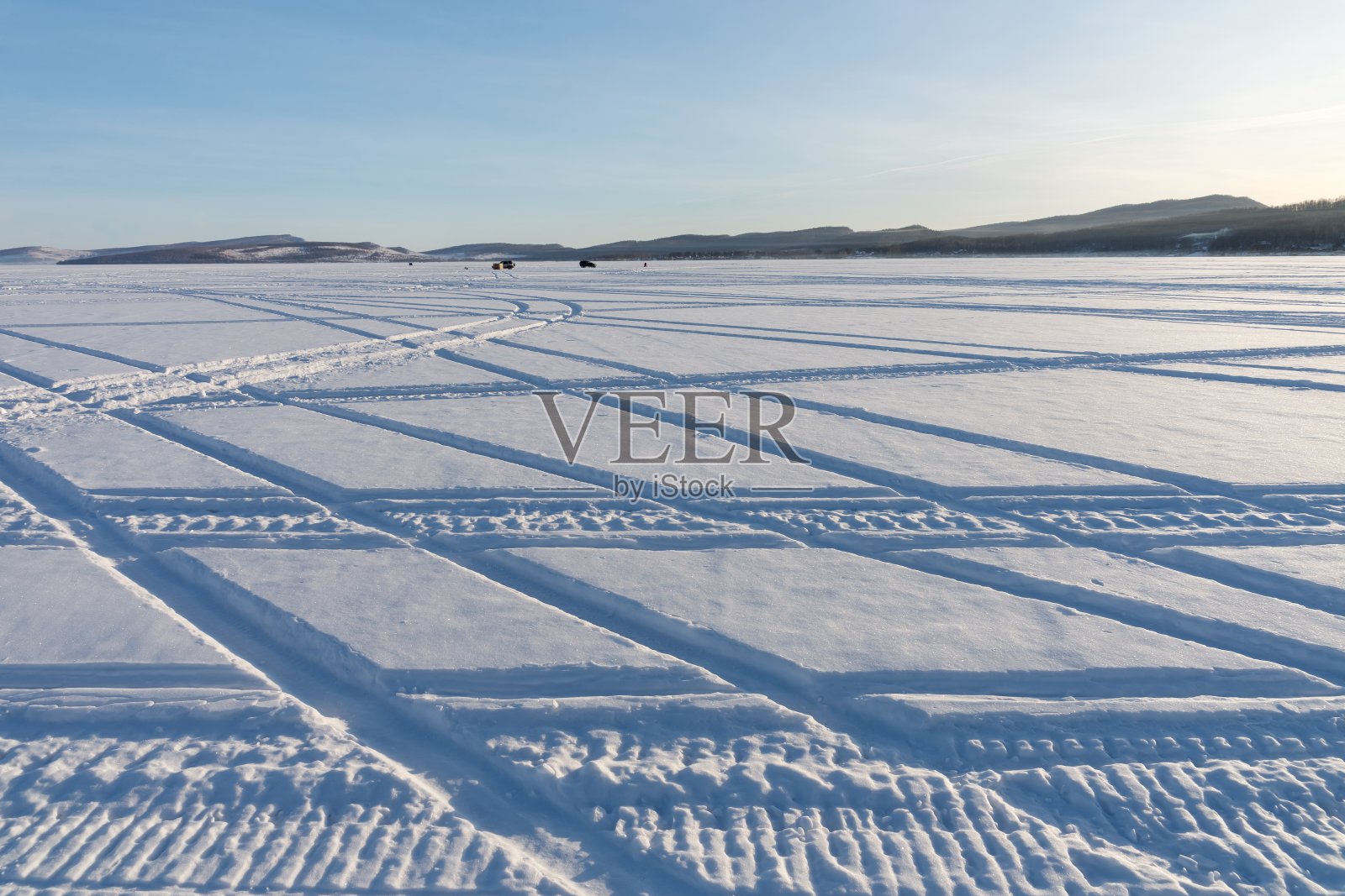 大湖冰面上汽车轨迹的几何图案。照片摄影图片