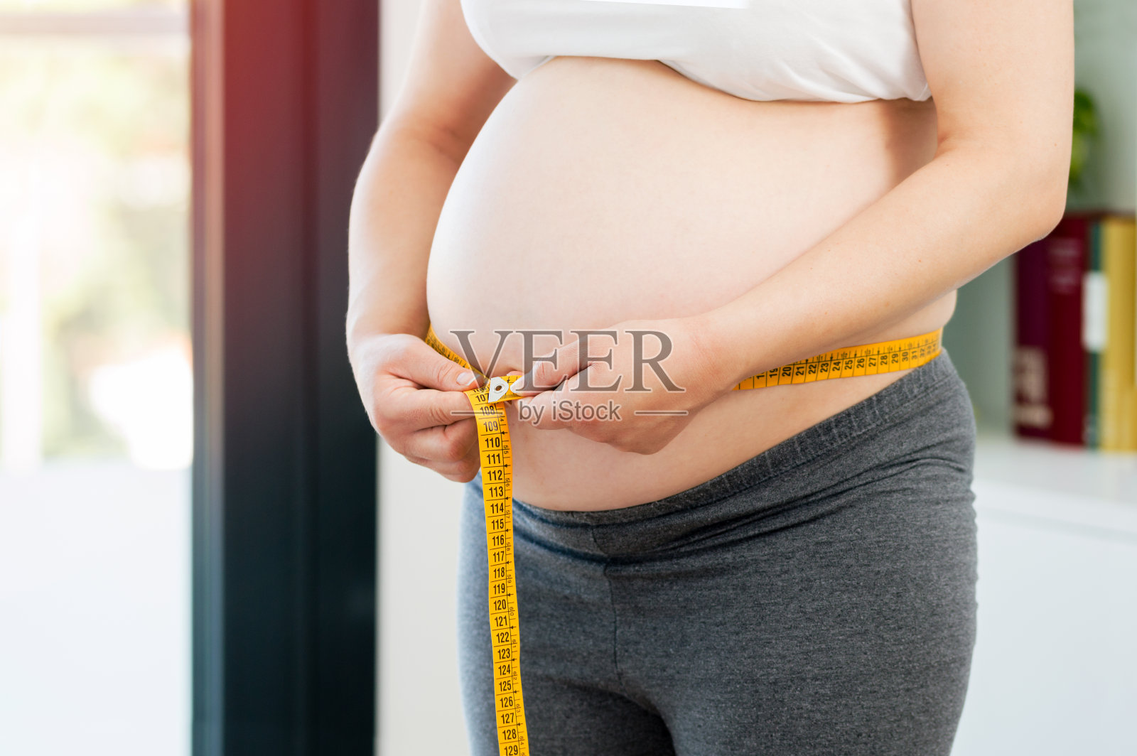 孕妇在家测量自己的肚子照片摄影图片