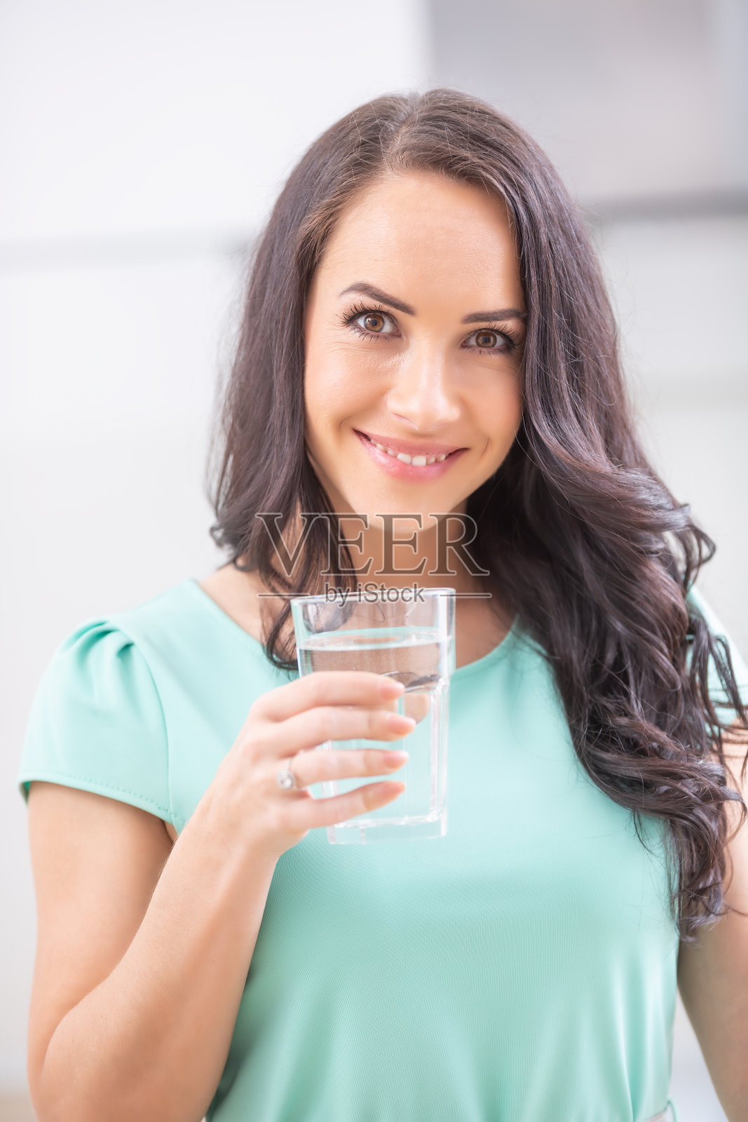 年轻女子喝干净的水，坚持饮用制度。照片摄影图片