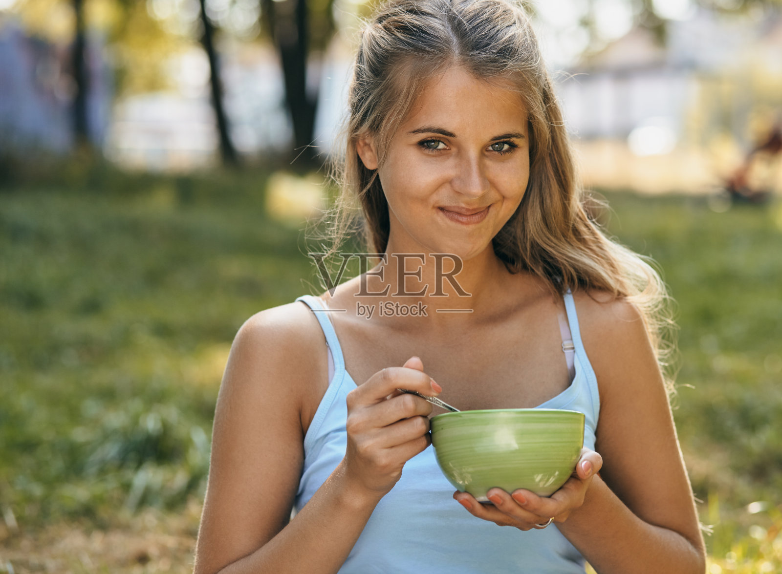 快乐微笑的年轻女子吃面条的肖像照片摄影图片