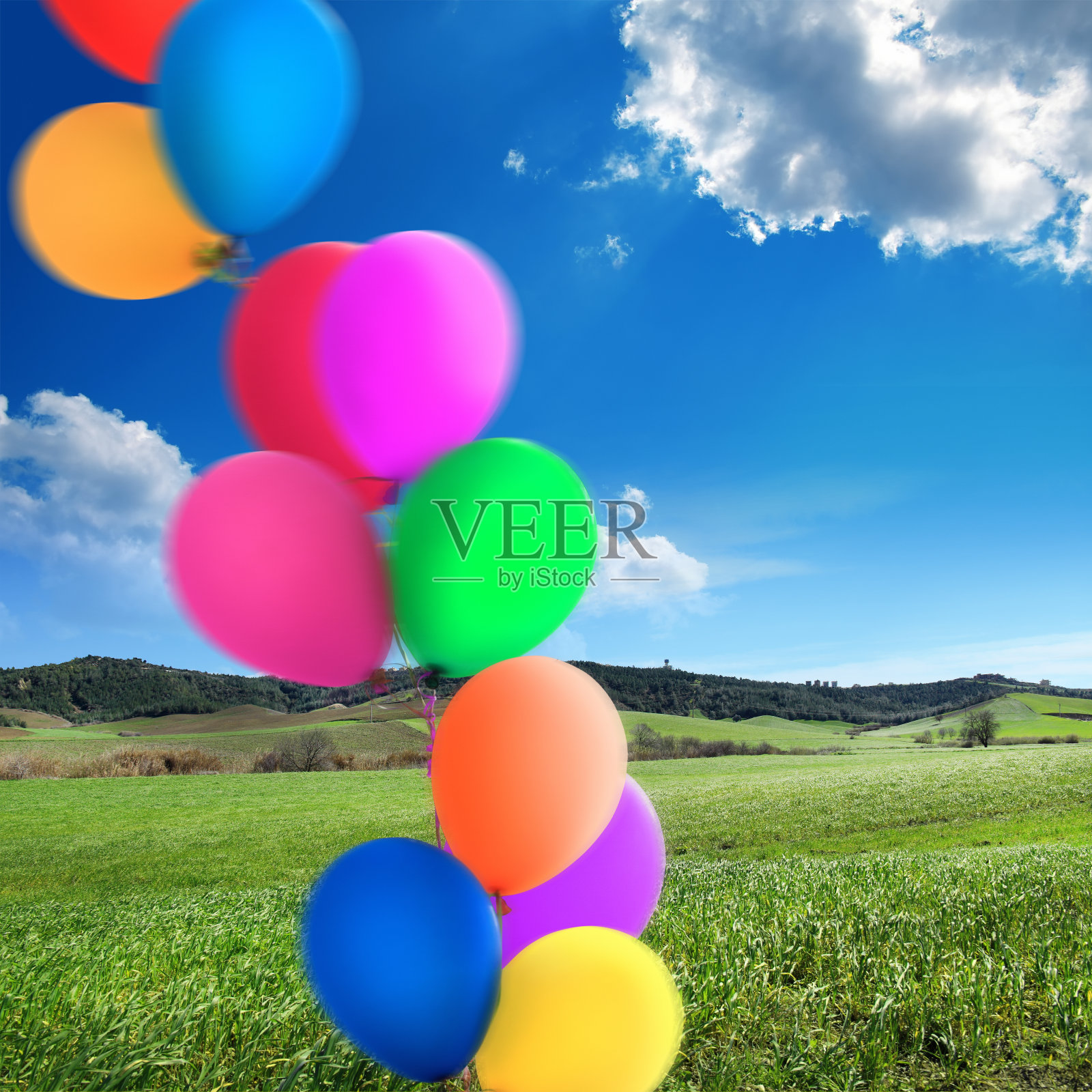 五颜六色的气球堆在绿色的风景照片摄影图片