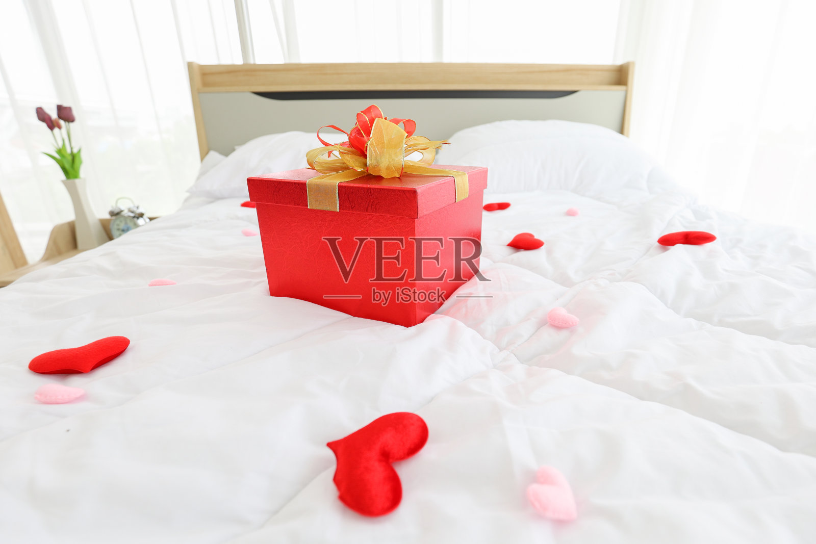 红色礼盒作为礼物在床上惊喜你的伴侣在新婚夫妇为情人节和爱情概念与拷贝空间照片摄影图片