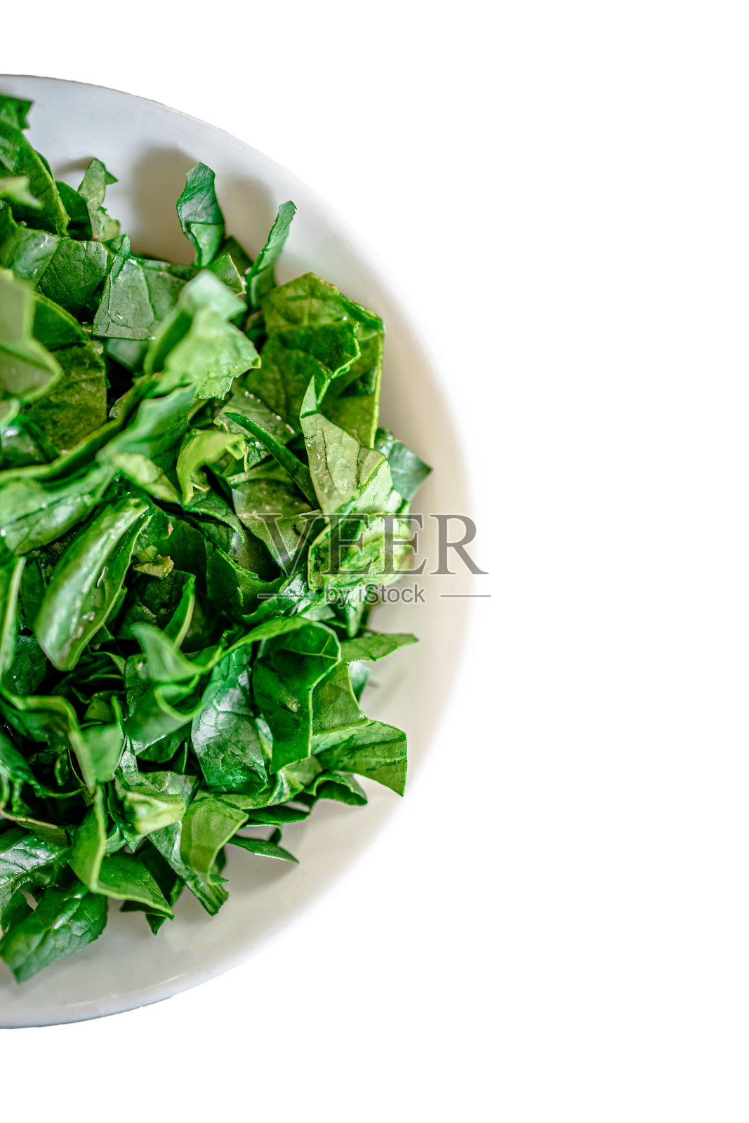 新鲜多汁的绿色菠菜切片在白色的碗中孤立在白色的背景上。平的。本空间照片摄影图片