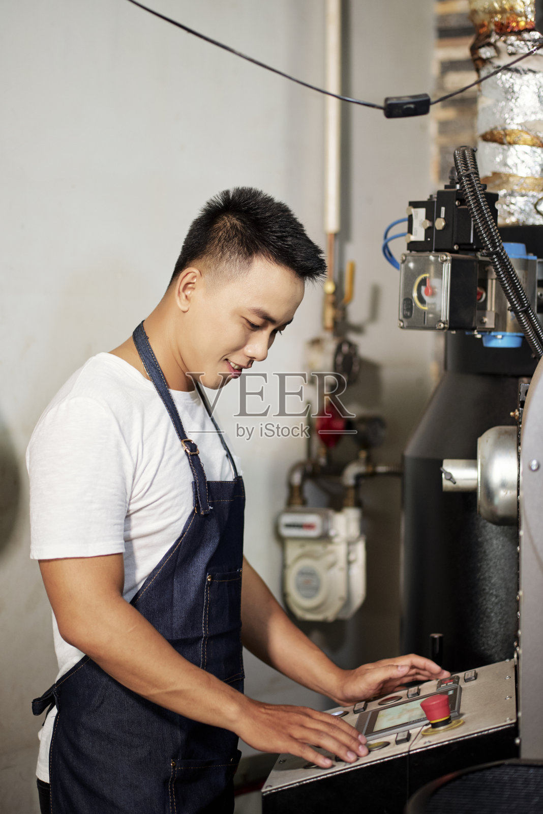 男子操作咖啡烘焙机照片摄影图片