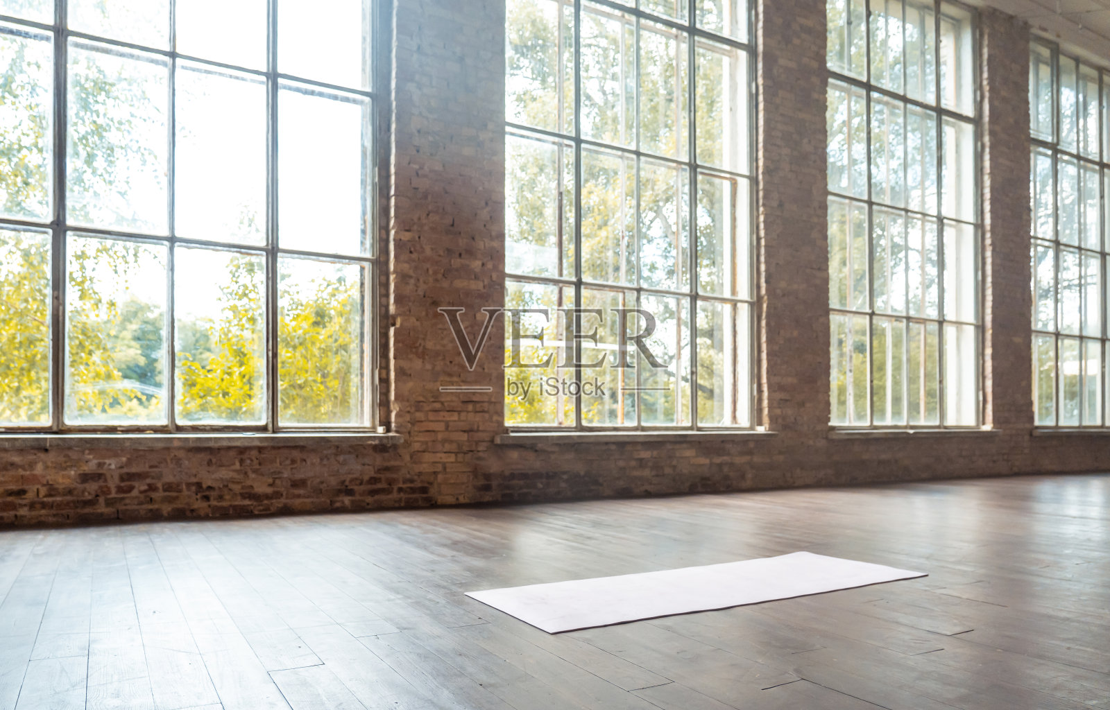 木质地板上的白色垫子空现代宽敞的健身房私人健身教室运动俱乐部工作室班训练日光大窗户砖墙锻炼瑜伽健康生活方式概念复制空间照片摄影图片