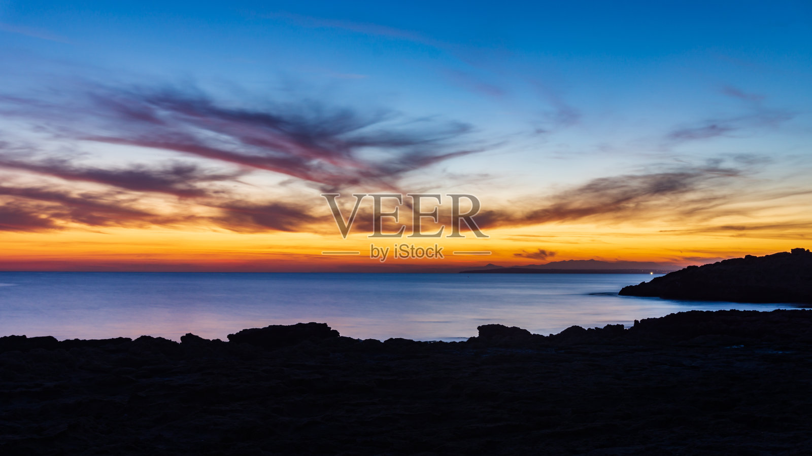 塞浦路斯美丽的日落在海上与岩石和多云的天空照片摄影图片