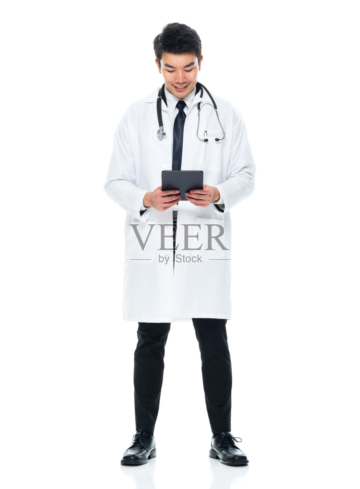 东亚人种年轻男医生站在白色背景下，穿着实验室大褂，使用触摸屏照片摄影图片