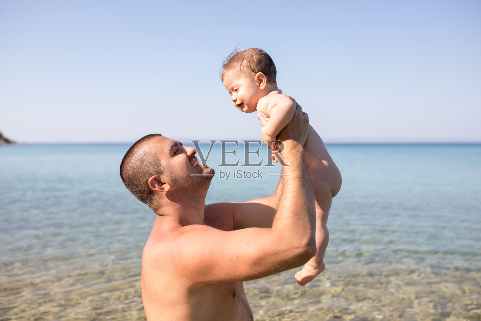 父亲和儿子在海滩上享受阳光照片摄影图片