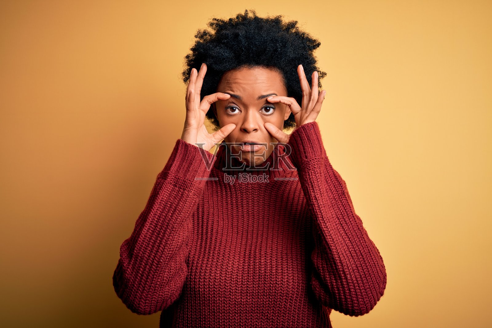 年轻美丽的非洲裔美国妇女卷发穿着休闲的高领毛衣试图用手指睁开眼睛，困倦和疲倦的早晨疲劳照片摄影图片