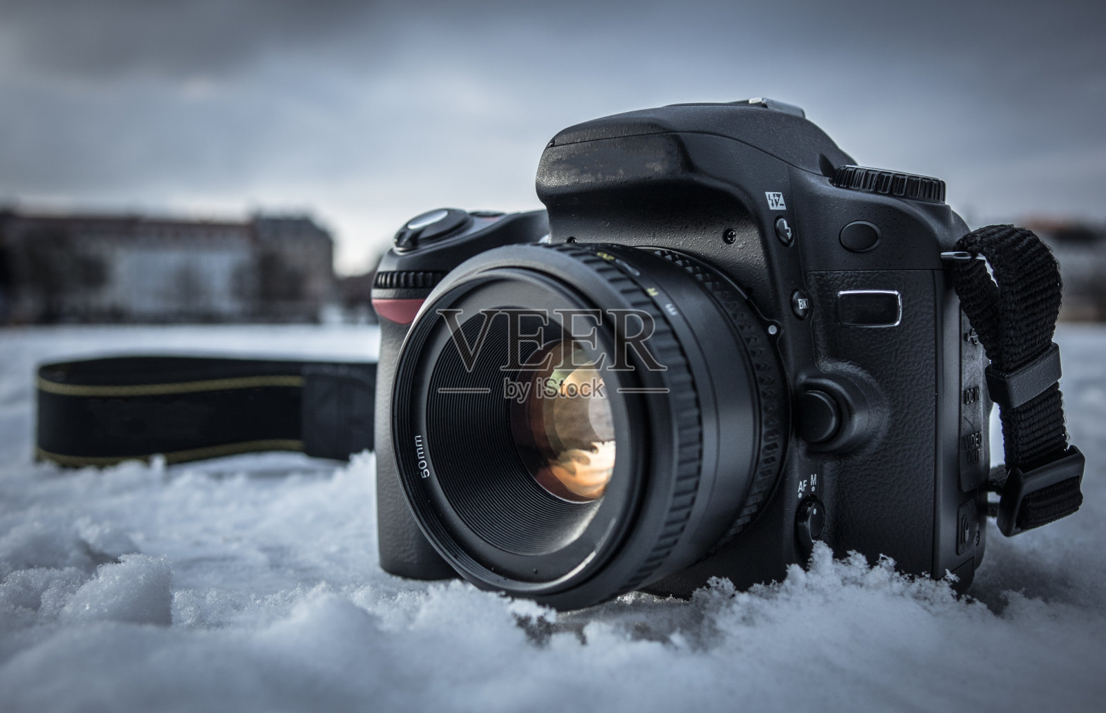 雪地里的现代单反相机。照片摄影图片