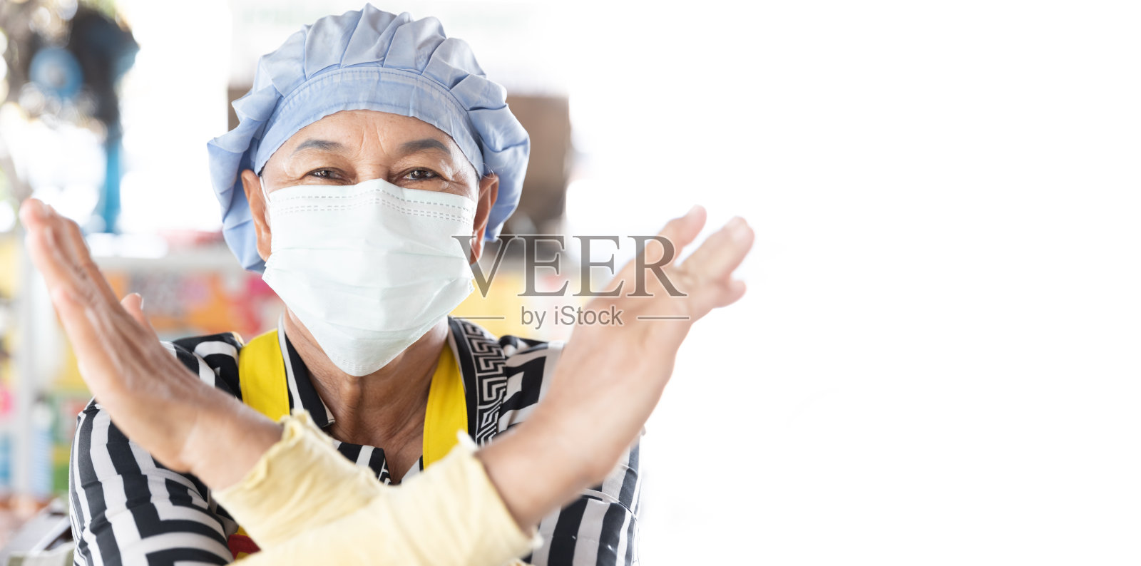 亚洲女人的近距离脸。带口罩的烹饪妇女保护病毒，并展示停止手势照片摄影图片