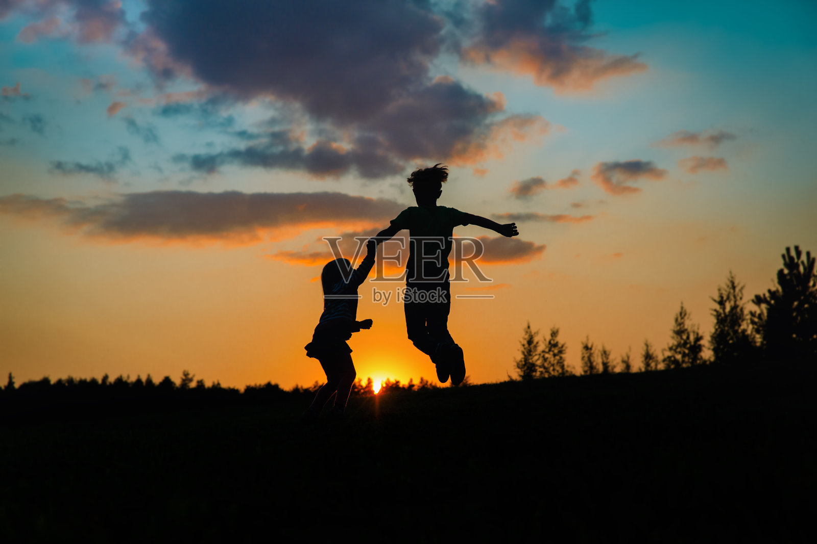 剪影快乐的男孩和女孩享受日落的自然照片摄影图片