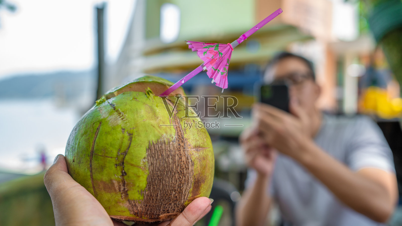 人的手拿着一个新鲜的椰子照片摄影图片