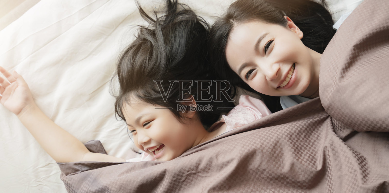 幸福亚洲家庭时刻妈妈和女儿玩和躺在白色的床上的毛毯家庭室内背景照片摄影图片