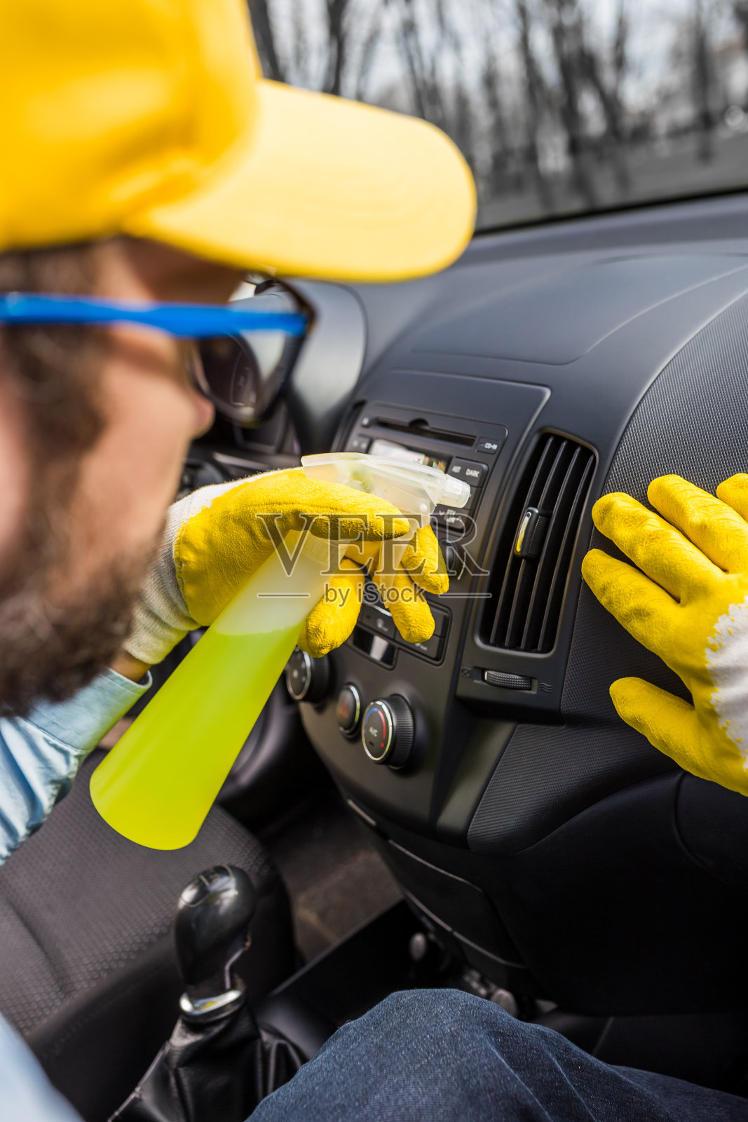 专业工人用消毒剂清洗汽车仪表盘。照片摄影图片