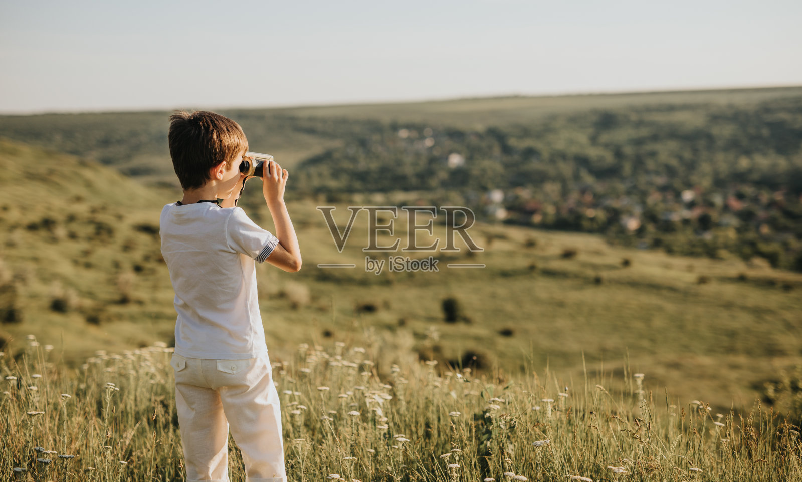 男孩用双筒望远镜探索大自然照片摄影图片