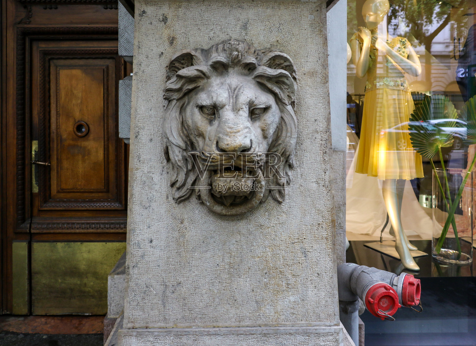 布达佩斯一座古老建筑的外面，一尊石雕狮头，嘴里叼着一圈。狮头象征着勇敢、勇敢、力量、凶猛和庄严的品质照片摄影图片