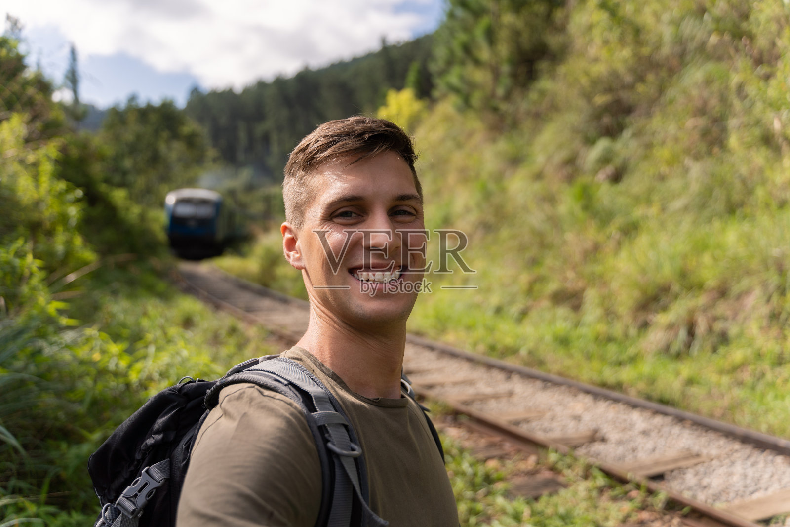 斯里兰卡火车前的埃拉森林里，一名男子在微笑照片摄影图片