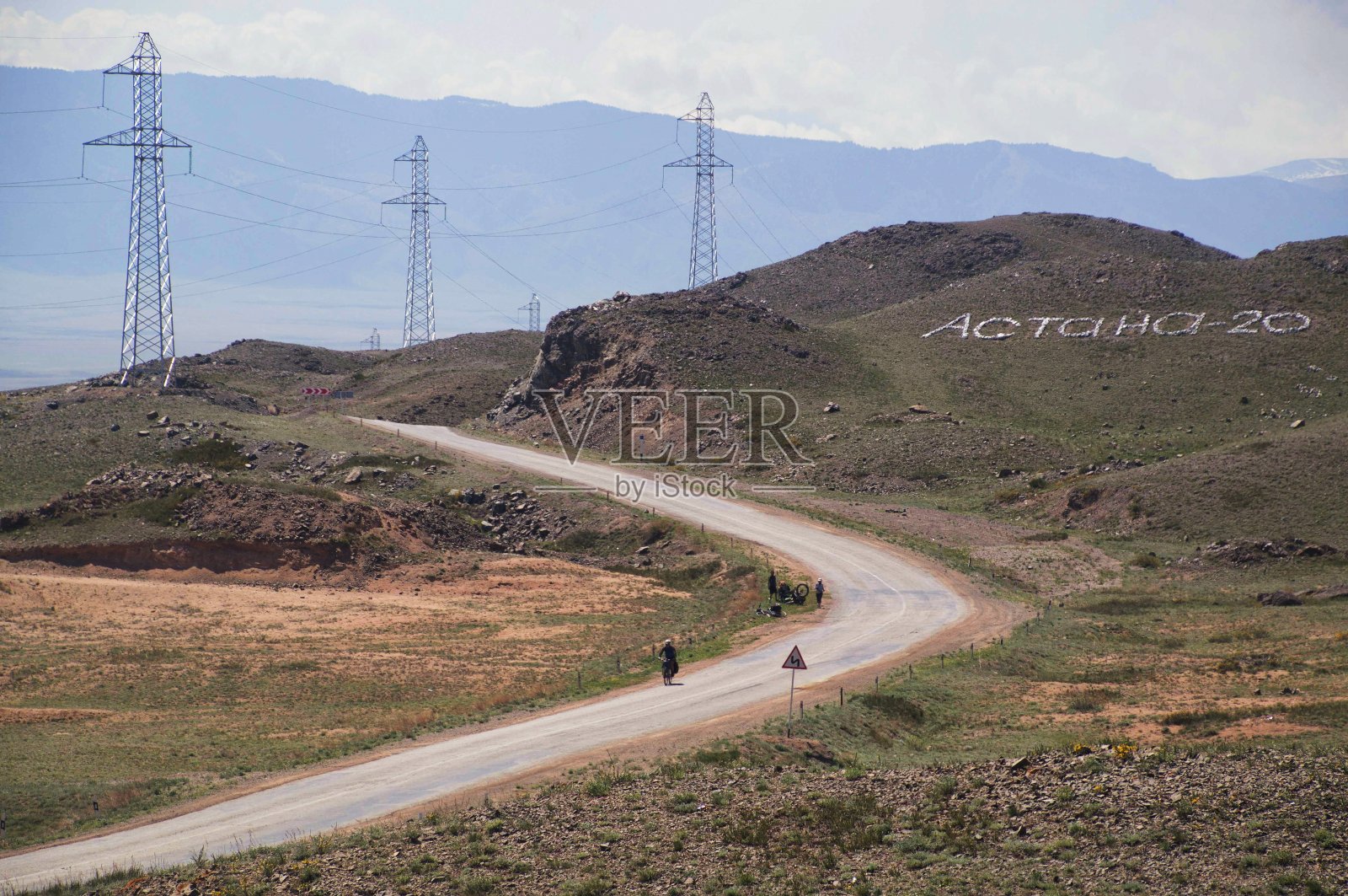 两名骑自行车的人在哈萨克斯坦南部的高海拔公路上照片摄影图片