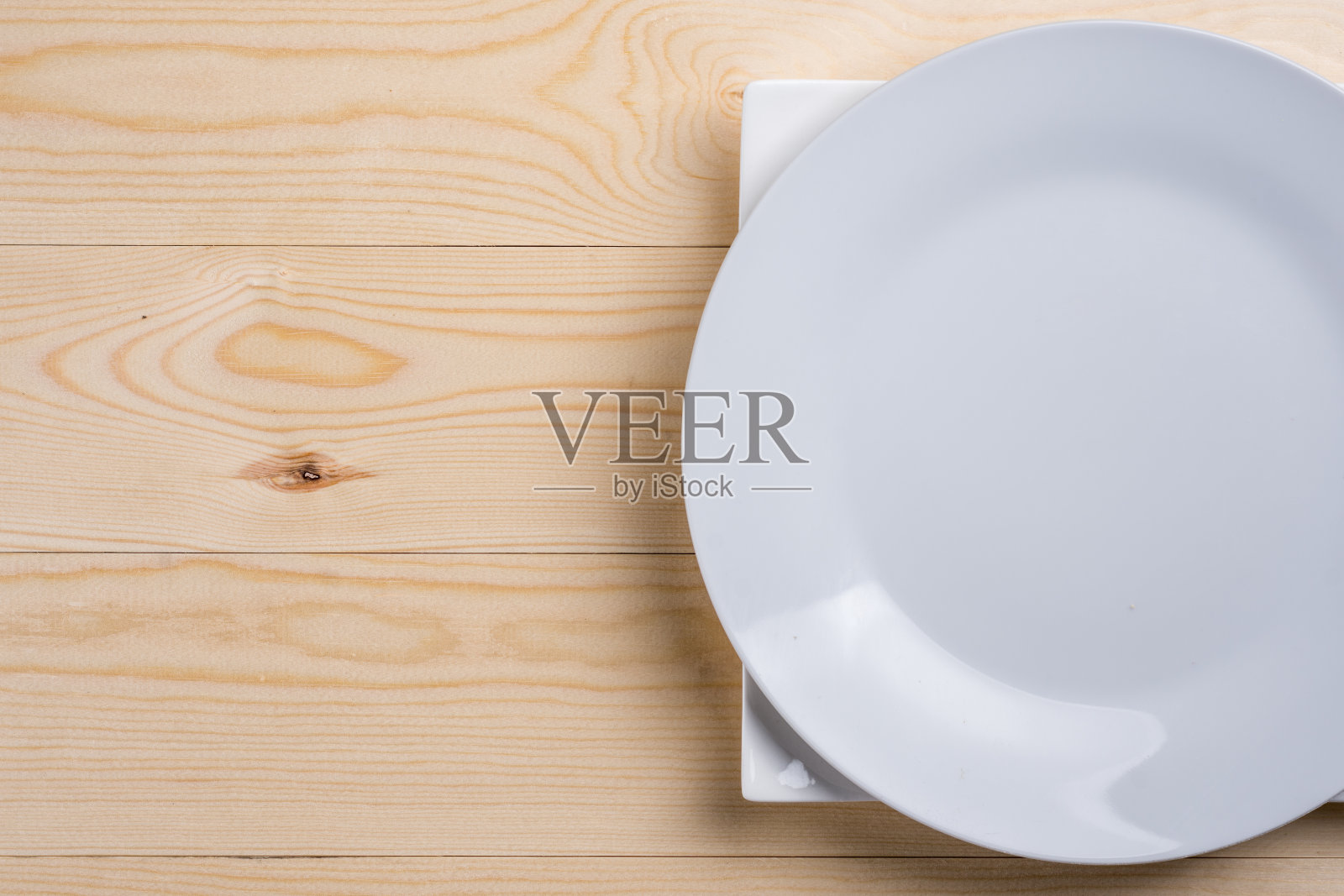 平放在上面的空白的白色盘子上的木质纹理桌子与复制空间照片摄影图片