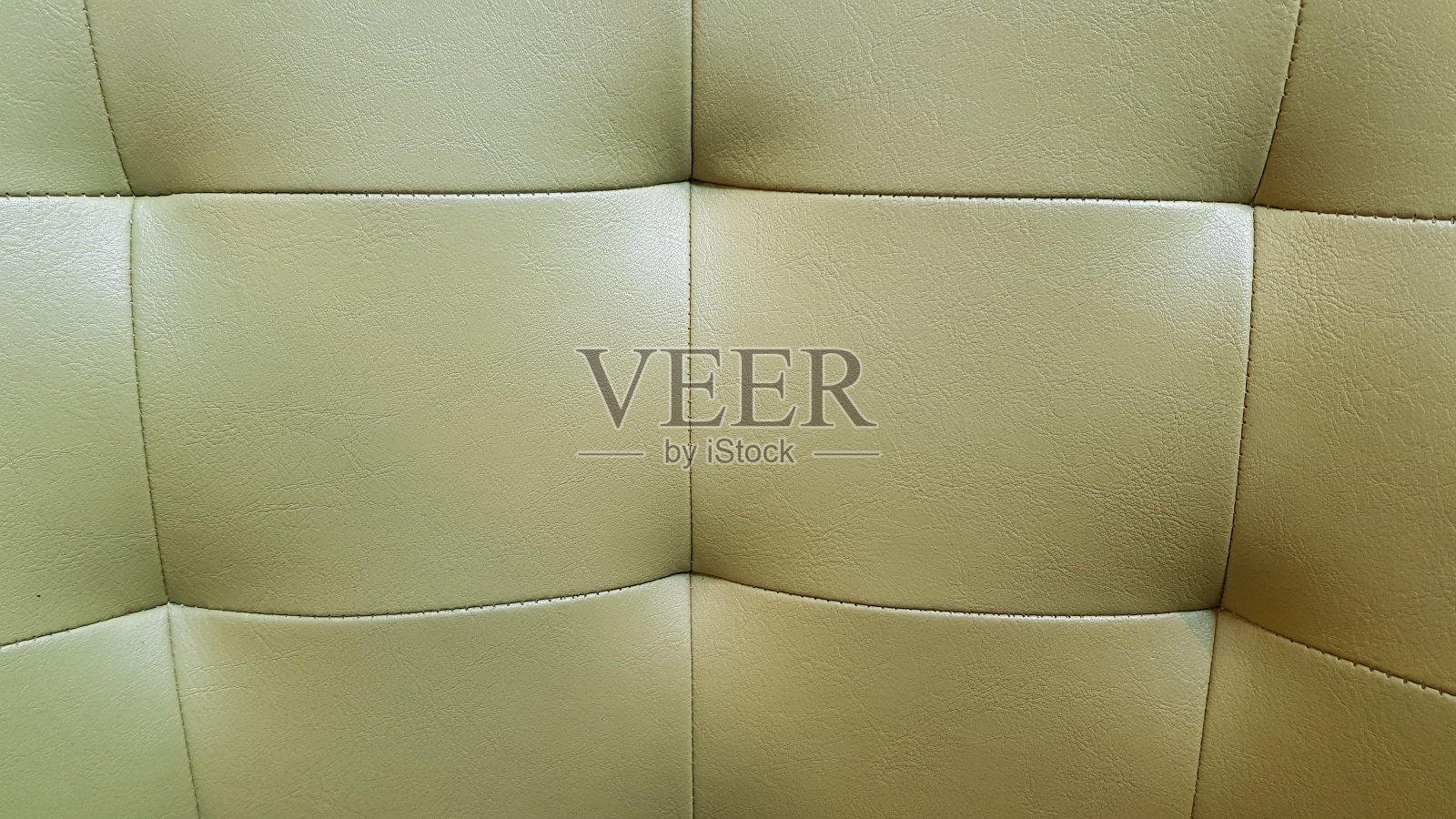 软垫家具的绿色哑光皮革表面。方形图案的现代沙发。由天然皮革制成的优雅室内装饰。照片摄影图片