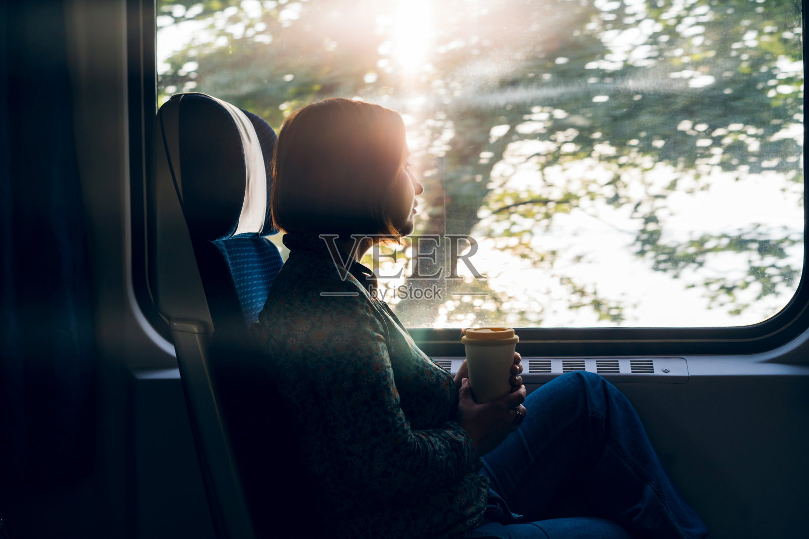 坐在通勤火车窗口旁的中年妇女照片摄影图片