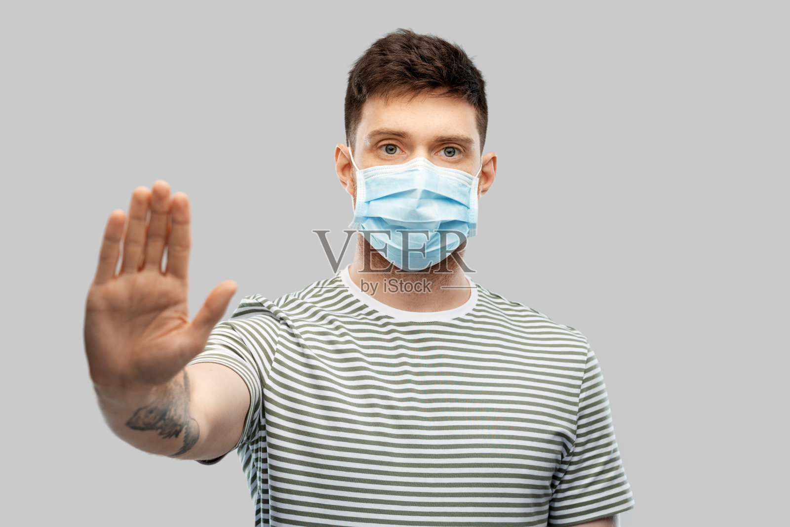 戴着医用防护面具的男人做着停止的手势照片摄影图片