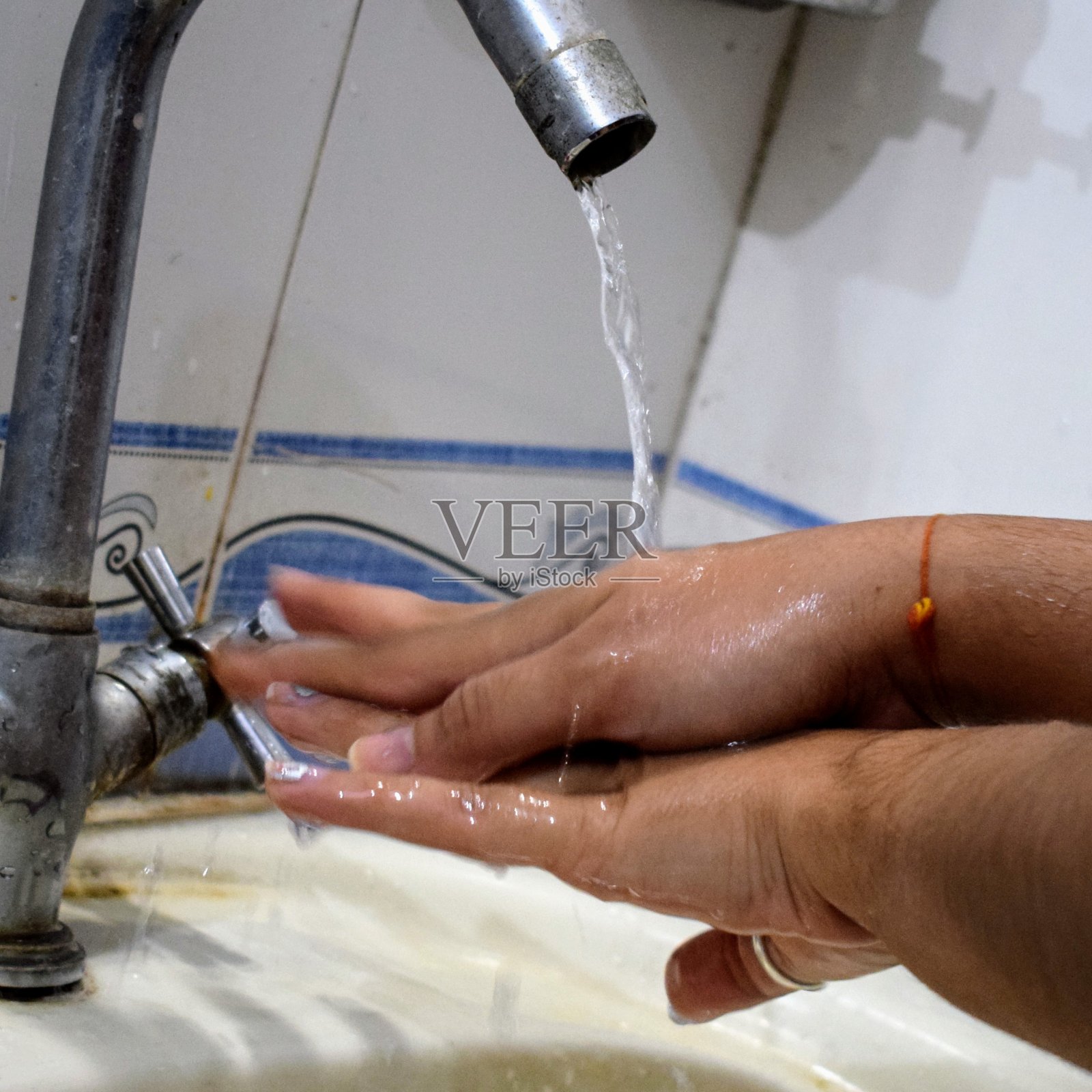 妇女用肥皂洗手，预防冠状病毒，防止传播冠状病毒，妇女用肥皂洗手，在水龙头下洗手。卫生概念手的细节照片摄影图片