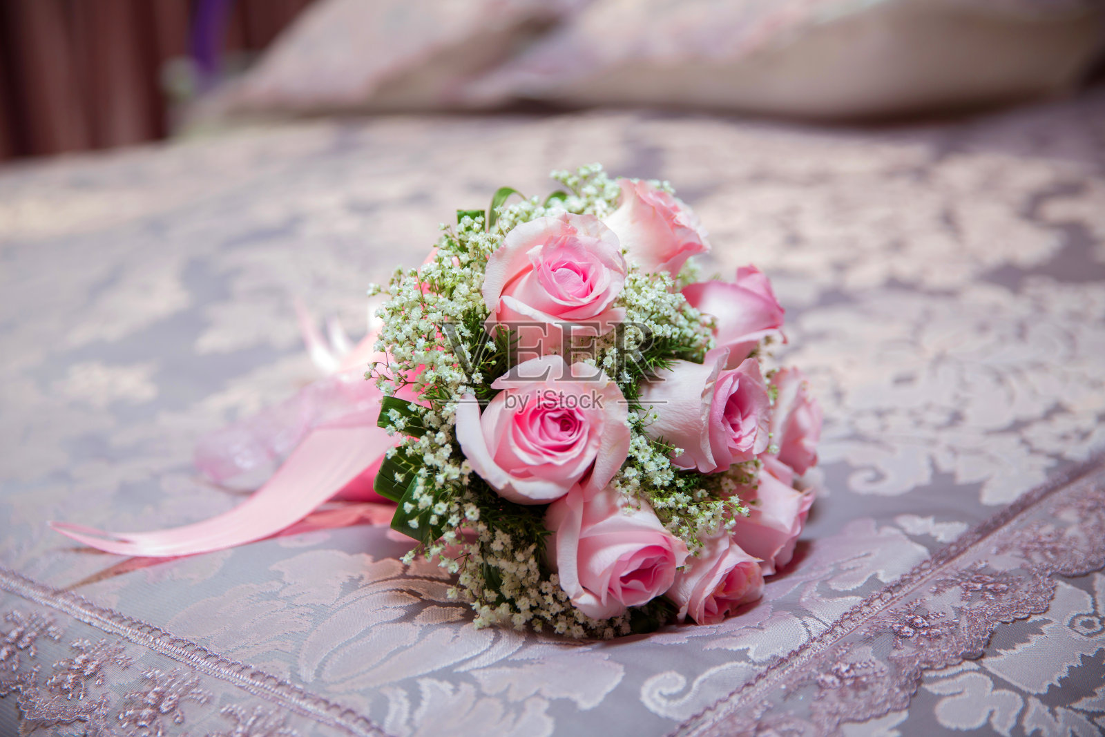白色桌上放着粉红色的订婚花。粉红色的订婚花束。粉红丝带。照片摄影图片