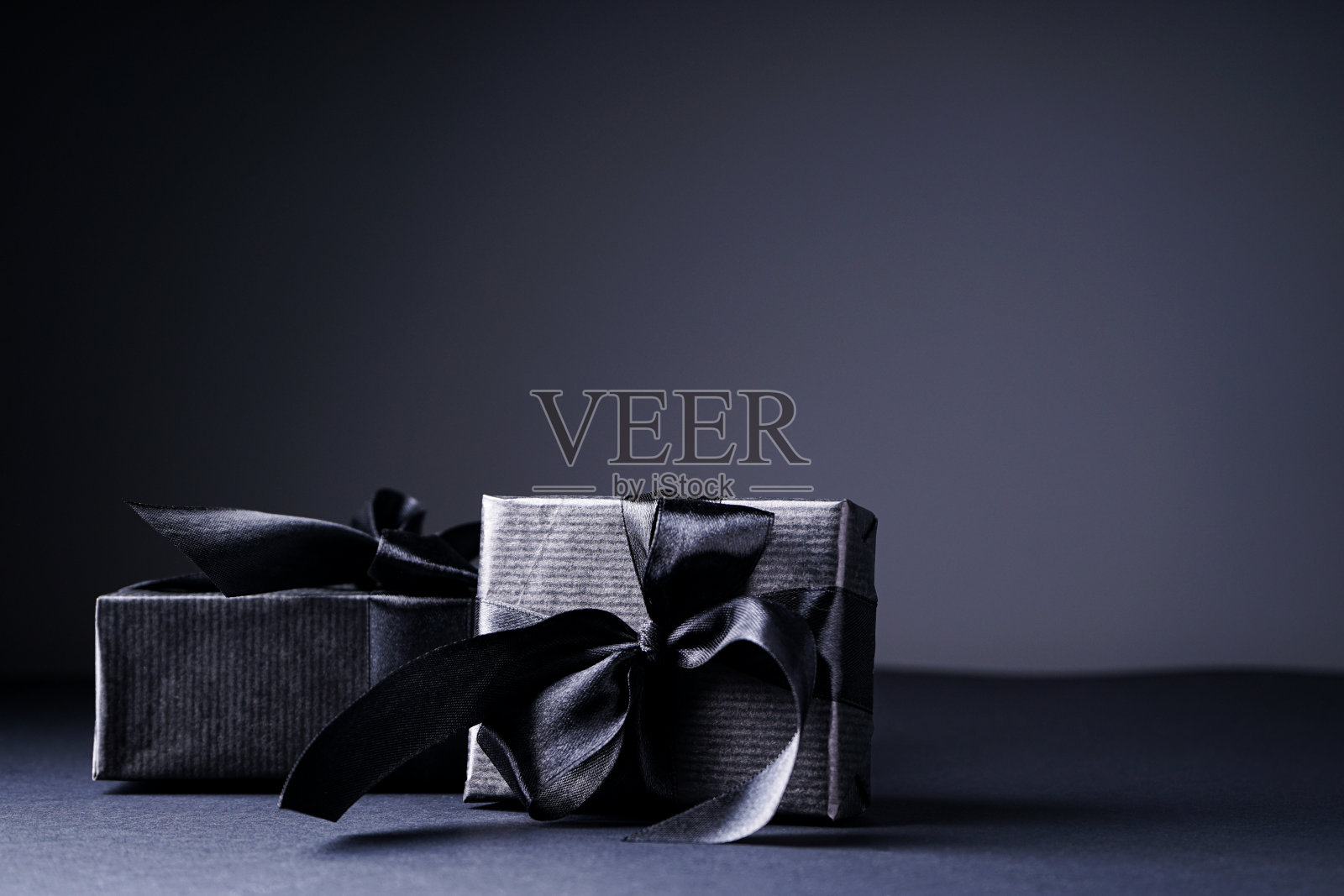 “黑色星期五”。礼品黑色包装，黑色丝带，黑色和灰色背景。照片摄影图片