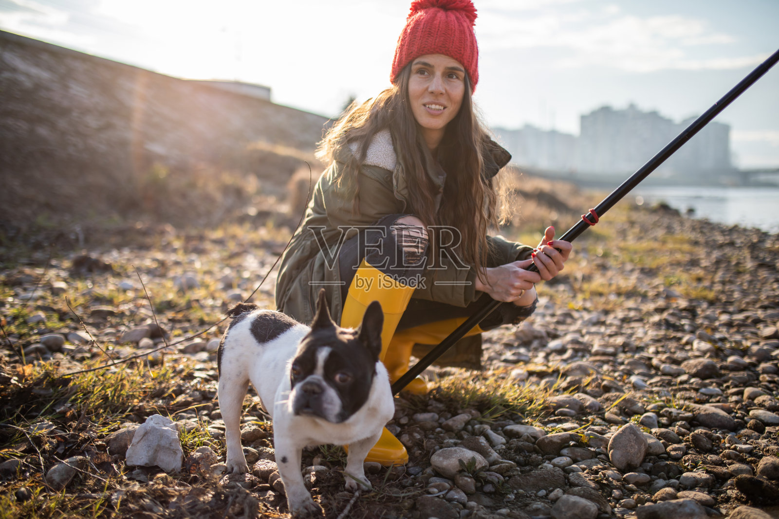一个年轻女子和她的狗在钓鱼照片摄影图片