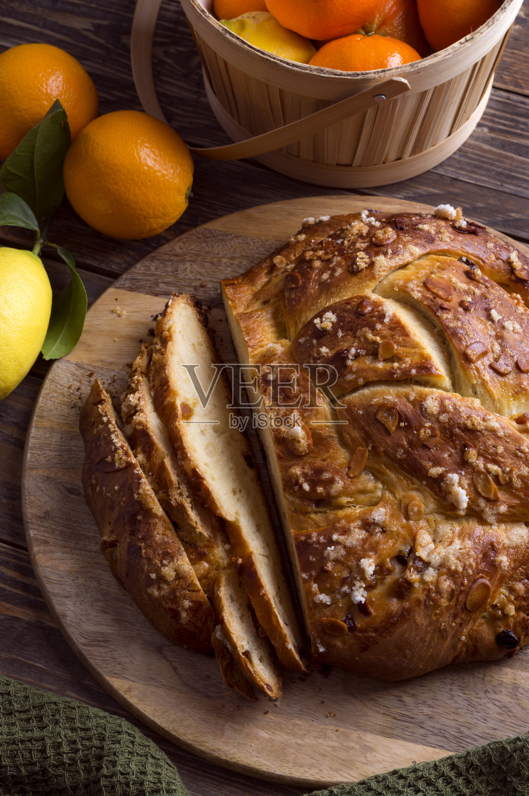 新鲜烘焙的甜编织面包，水果馅和杏仁片在木背景。传统的复活节庆祝甜点。照片摄影图片