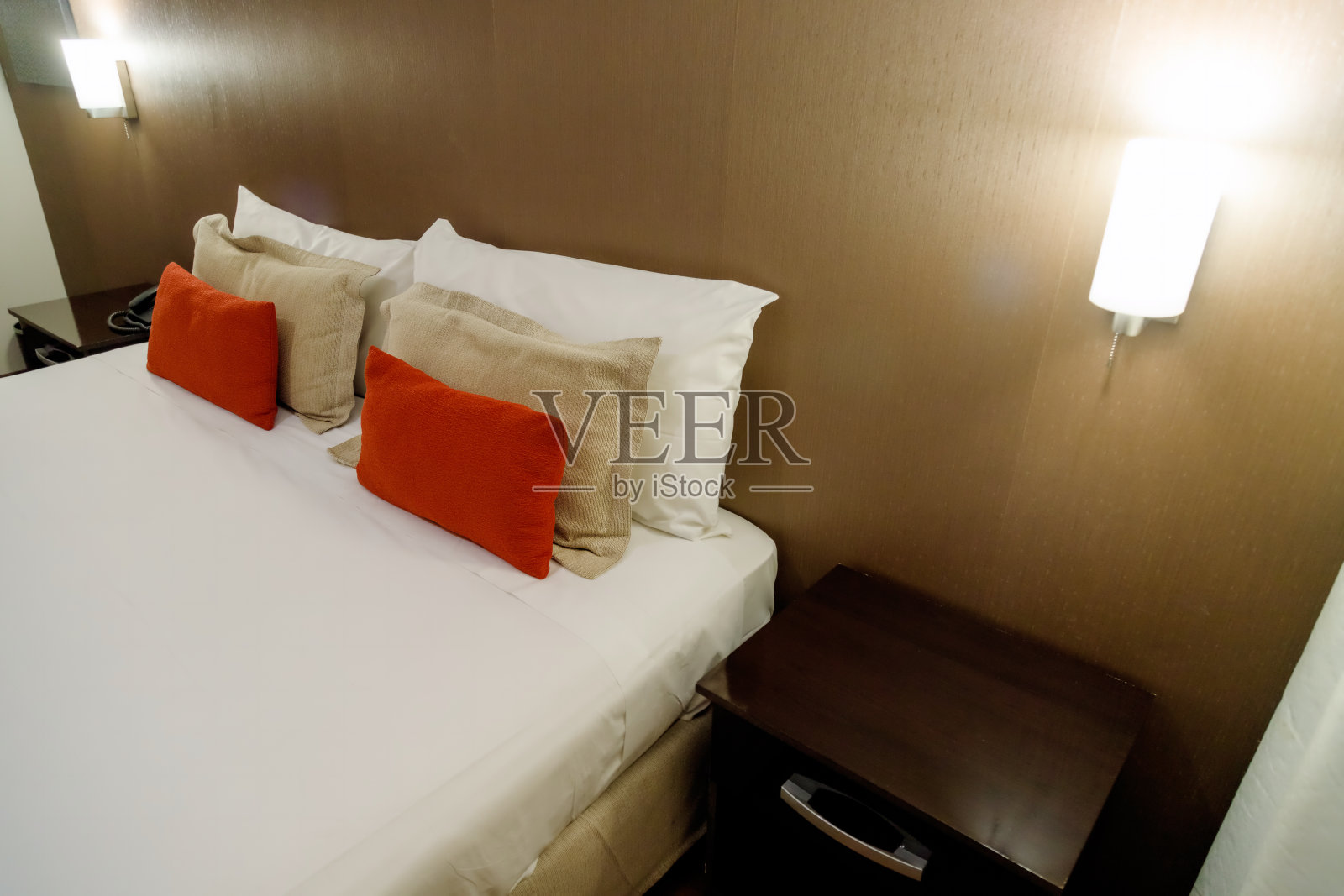 酒店的床上有红色的枕头和夜灯照片摄影图片