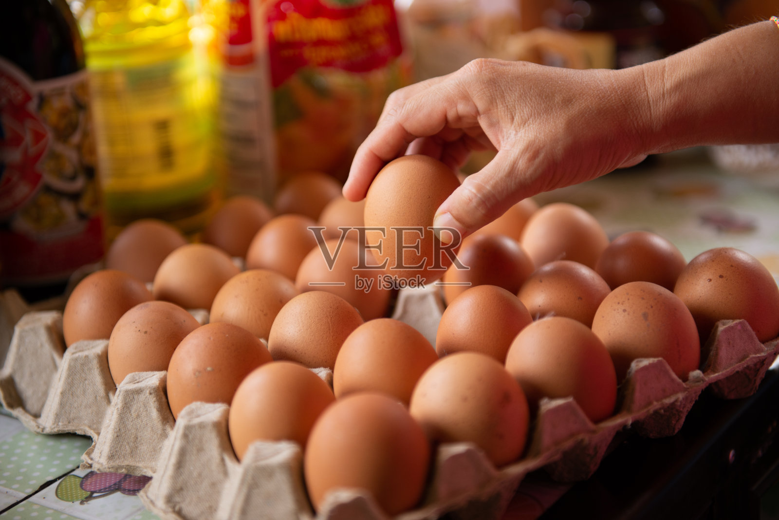 厨师从盘子里取出鸡蛋准备做饭。照片摄影图片