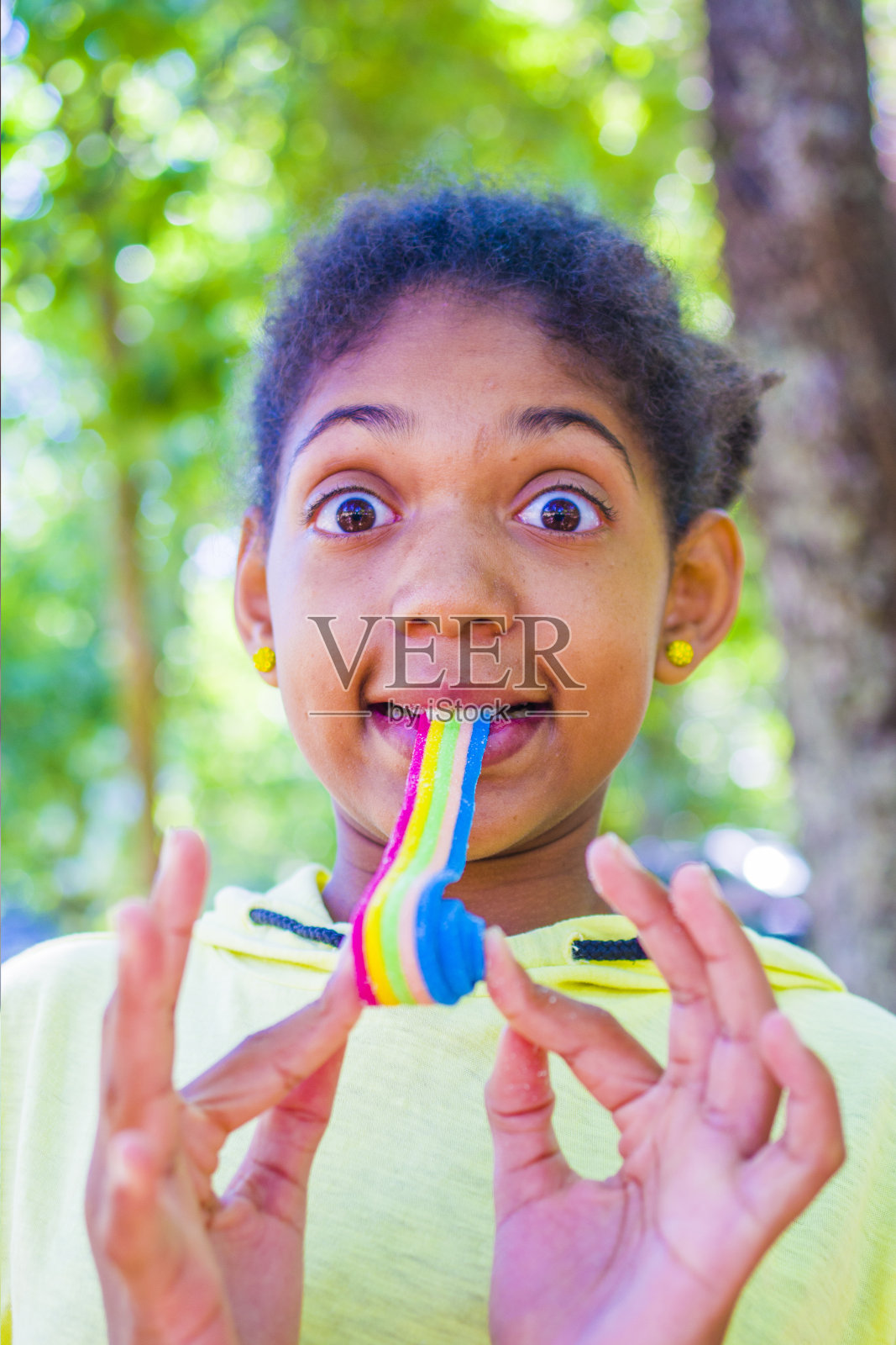 快乐的小女孩吃着柔软的彩色甘草照片摄影图片