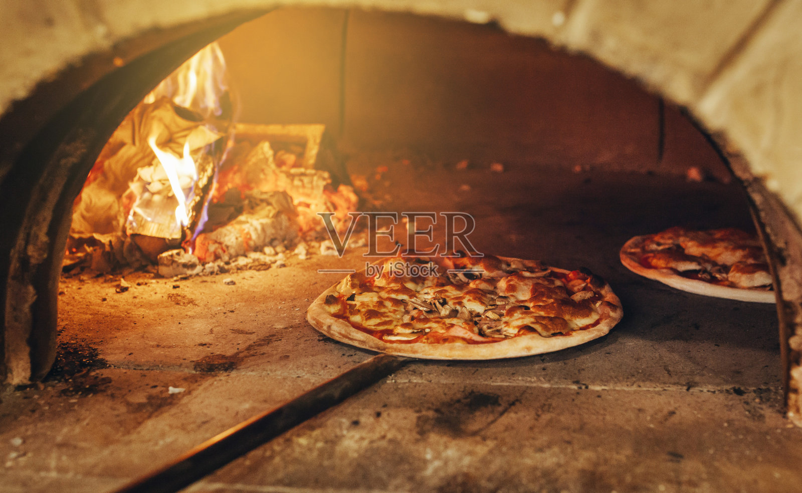 意大利披萨是在木头烤炉里烤的。照片摄影图片