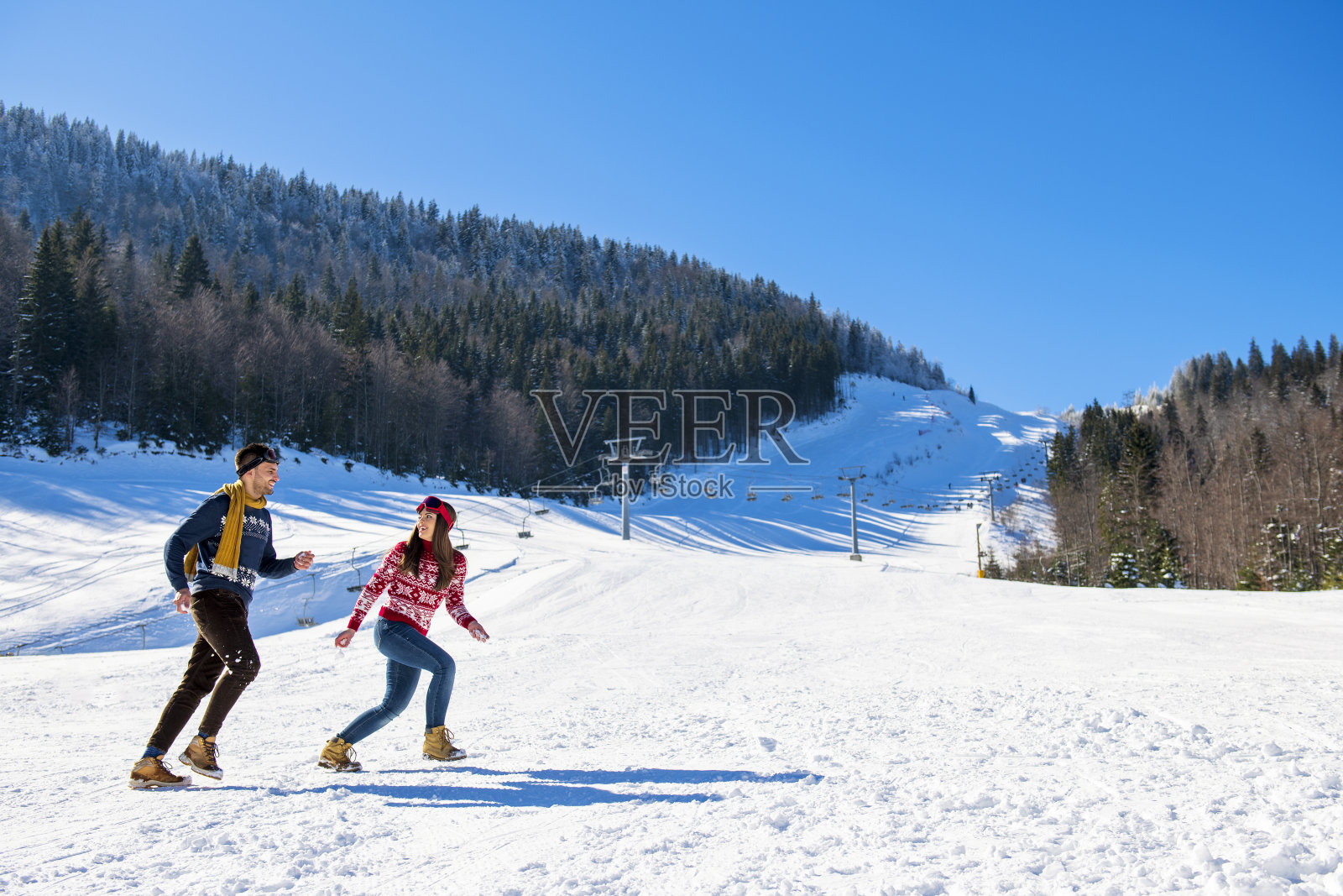 打雪仗。冬天的一对夫妇在户外玩雪。年轻快乐的多种族夫妇。照片摄影图片