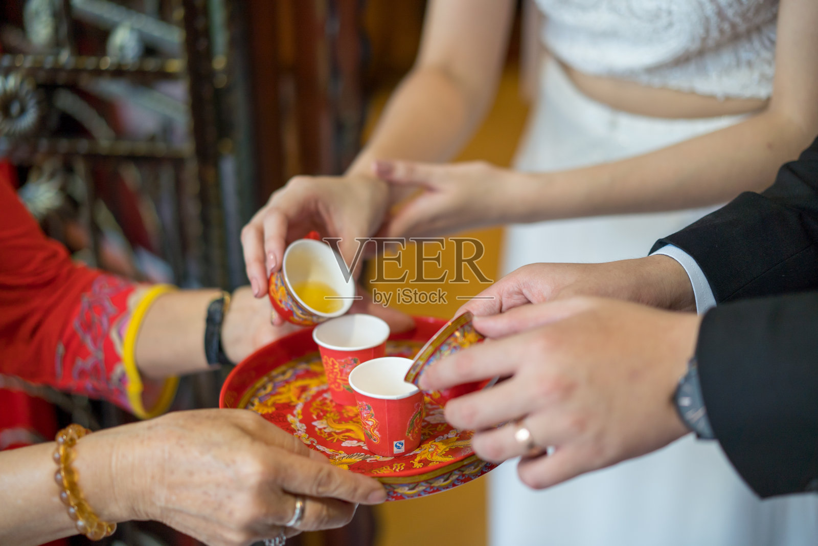 新婚夫妇在中国传统的茶道上给长辈敬茶，以示尊重照片摄影图片