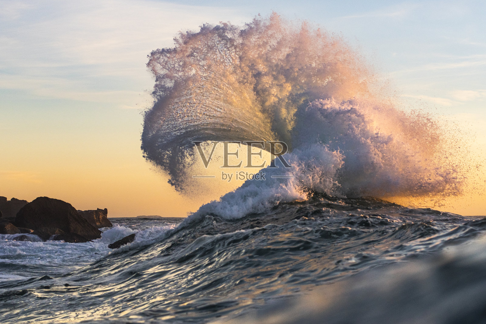在金色的阳光下，大海中爆发出强大的波浪照片摄影图片