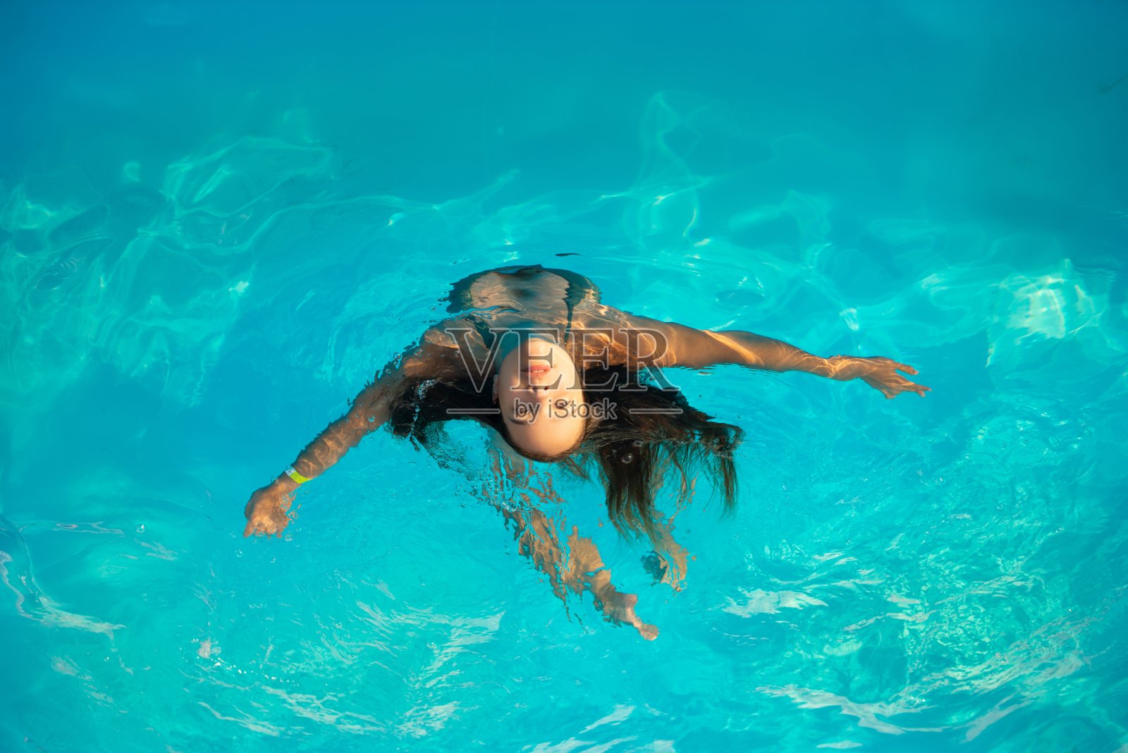 俯视图少女在游泳池游泳照片摄影图片