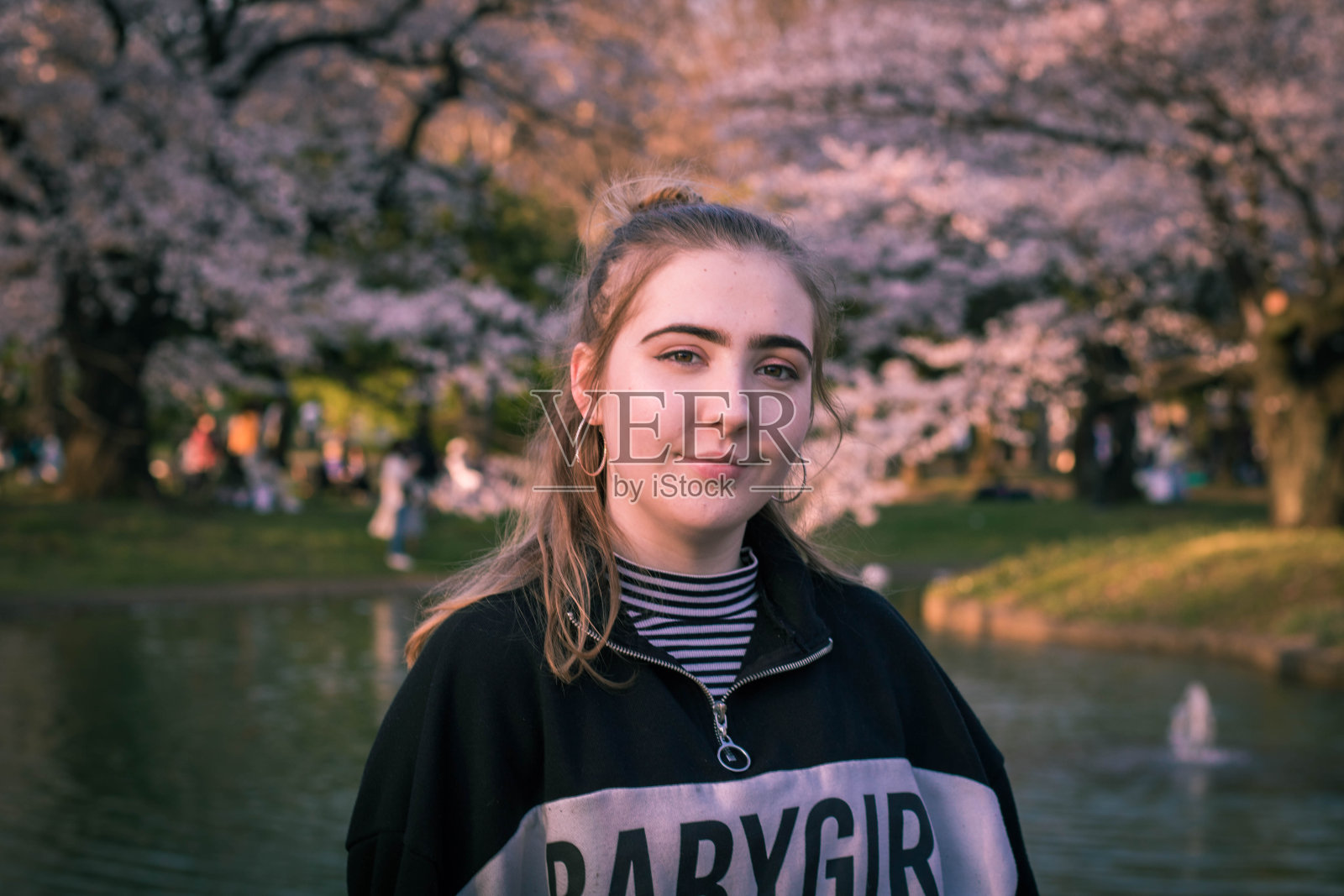 女游客在东京观看春天的樱花照片摄影图片