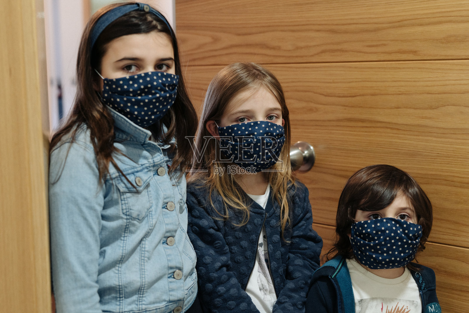 三个戴着面具的孩子站在门口照片摄影图片